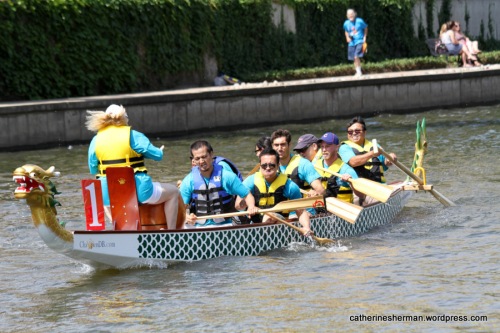 Thess dragon boat crew members paddle hard as they reach the finish in the International Dragon Boat Festival on June 14, 2014, on Brush Creek in the Country Club Plaza in Kansas City, Missouri.