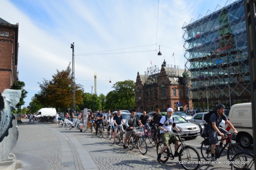 A crowd of bicyclists peddle rapidly at rush hour on H.C. Andersens Boulevard at the Town Hall Square in Copenhagen, Denmark.